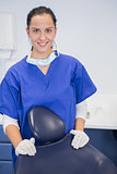 Portrait of a cheerful dentist behind a dentists chair