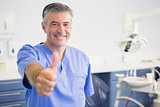 Portrait of happy dentist with thumbs up