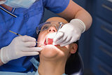Dentist examining a patient with angle mirror and sickle probe