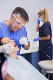 Dentist wearing face shield and examining a patient