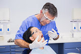 Dentist wearing face shield and doing injection to his patient
