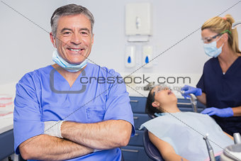 Portrait of a smiling dentist his arms crossed