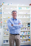 Portrait of a smiling pharmacist standing with arms crossed