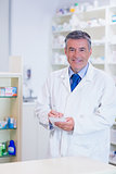 Pharmacist with grey hair writing down notes