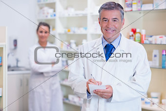 Pharmacist and his trainee with arms crossed behind