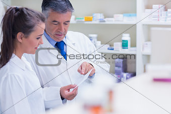 Pharmacist explaining a prescription to his trainee