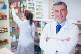Pharmacist looking at camera with student behind him