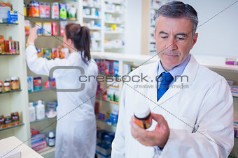 Man holding a box of pills while reading the label