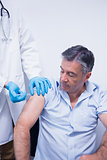 Doctor giving injection to his patient