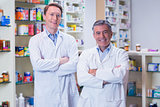 Smiling pharmacists standing with arms crossed
