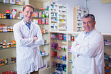 Smiling pharmacists standing with arms crossed