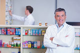 Smiling pharmacist standing with arms crossed