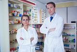 Pharmacist and his trainee standing with arms crossed