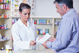 Customer handing a prescription to a trainee