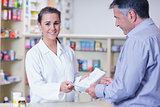 Customer handing a prescription to a smiling trainee