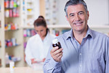 Smiling man with a bottle of pills