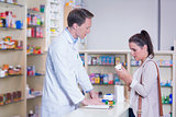 Customer talking to a pharmacist while holding a box of pills
