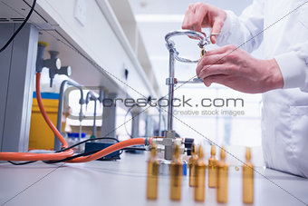 Close up of a biochemist sealing a vial