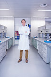 Smiling biochemist standing with arms crossed