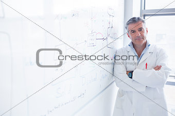 Smiling scientist leaning against the whiteboard