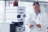 Scientist standing in lab coat reading analysis