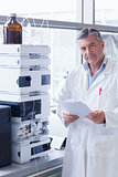 Scientist standing in lab coat holding a document