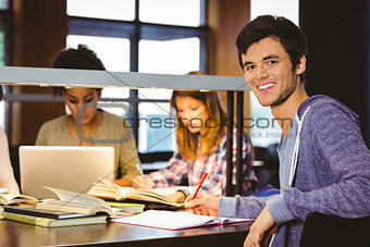 Student looking at camera with his classmates behind him