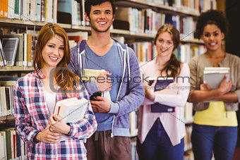 Happy students holding books in row