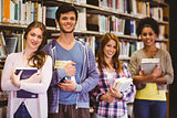 Happy students holding books in row