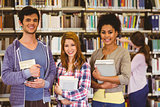 Students standing and smiling at camera holding books