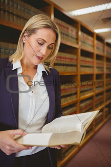 Serious librarian reading a book