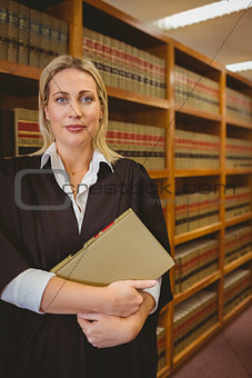 Serious lawyer holding a file while standing