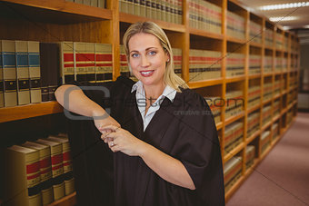 Smiling lawyer leaning on shelf