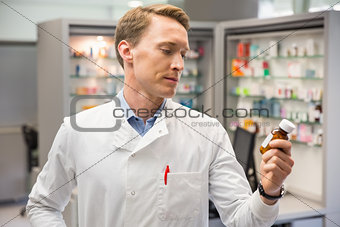 Handsome pharmacist looking at medicine
