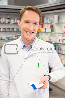 Happy pharmacist holding medicine boxes