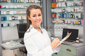 Pharmacy intern writing on clipboard