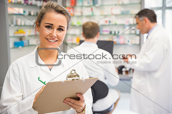 Junior pharmacist writing on clipboard