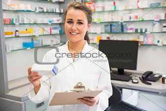 Junior pharmacist holding medicine box