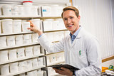 Handsome pharmacist taking medicine from shelf