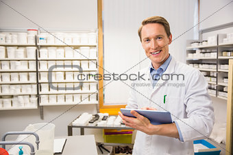 Happy pharmacist using tablet pc
