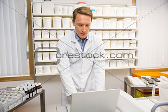Focused pharmacist using his laptop