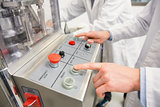 Pharmacist pressing button on machine