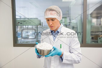 Pharmacist looking at bowl of pills