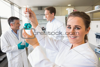Young scientist holding up beaker