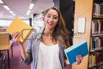 Pretty student smiling at camera in library