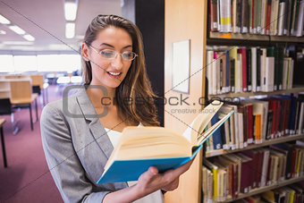 Pretty student reading book in library