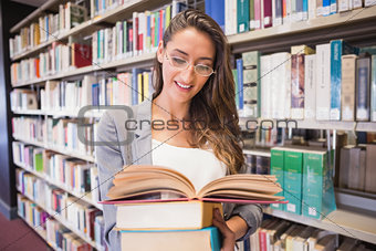 Pretty student reading books in library