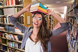 Pretty student holding books in library