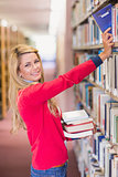 Mature student picking out book in library