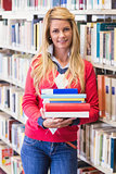 Mature student in library holding books